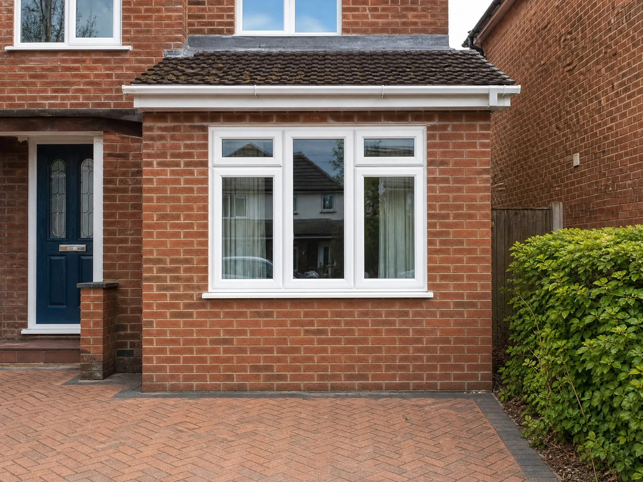 Former garage converted into a room, with matching red brickwork and a new white window